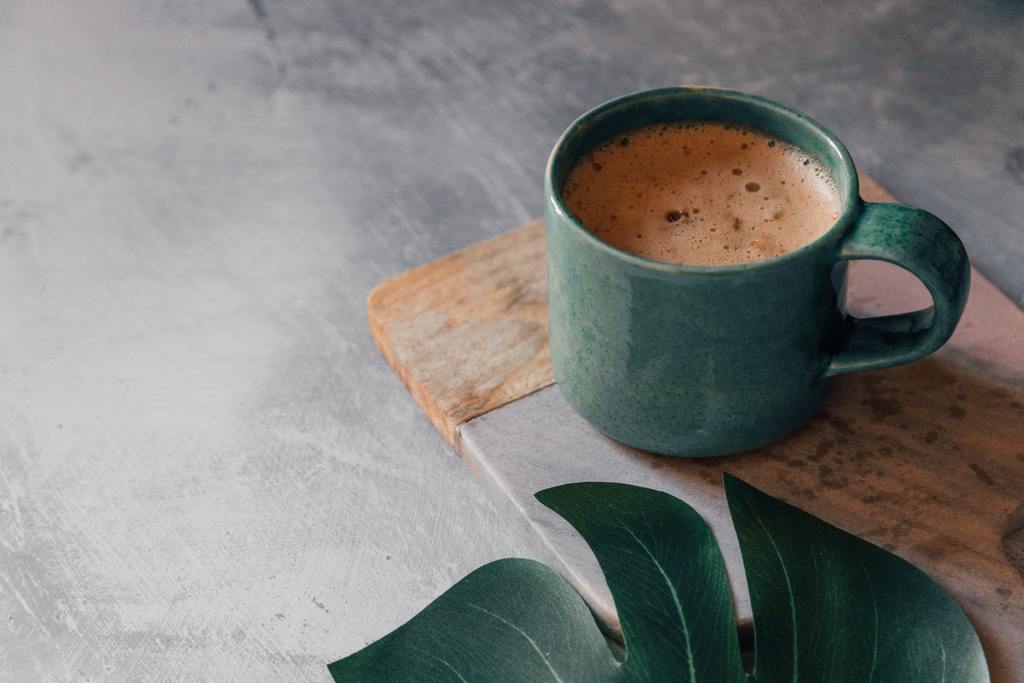 Green coffee cup filled with coffee